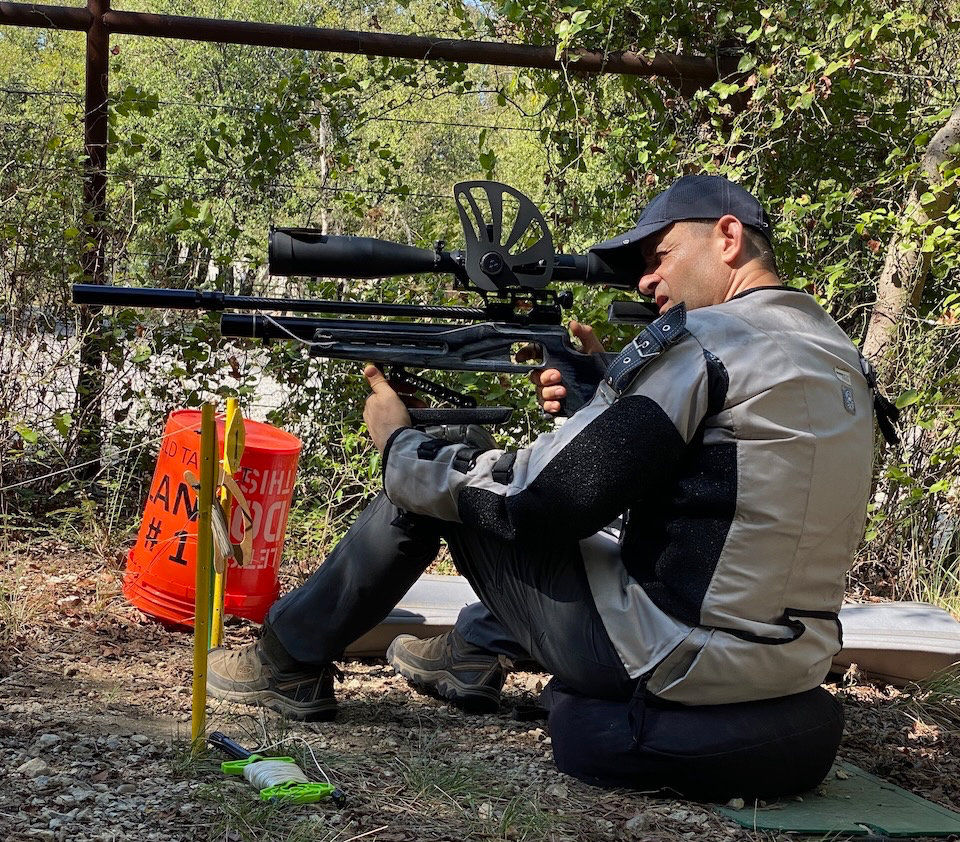 A person sitting on the ground holding an object  Description automatically generated