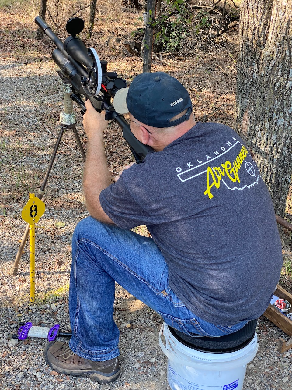 A person sitting on a stool looking at an object  Description automatically generated