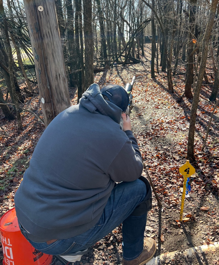 A person sitting on a bench in the woods  Description automatically generated